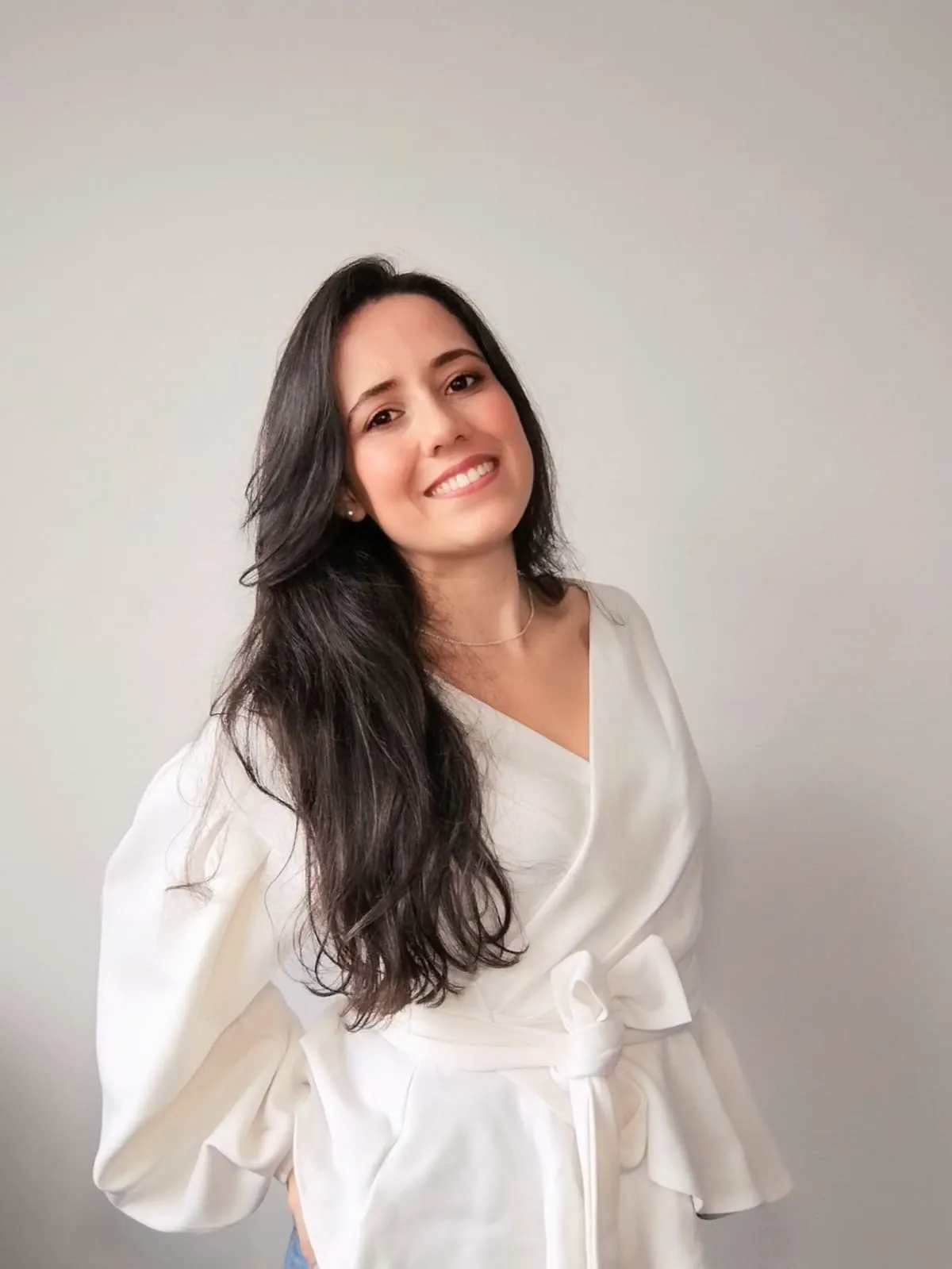 Kezia Duarte, psicóloga clínica, sorrindo, de blusa branca